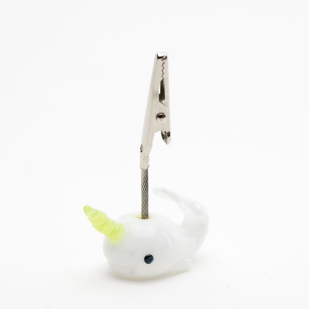 A roach clip shaped like a narwhal, with metal teeth to hold joints.