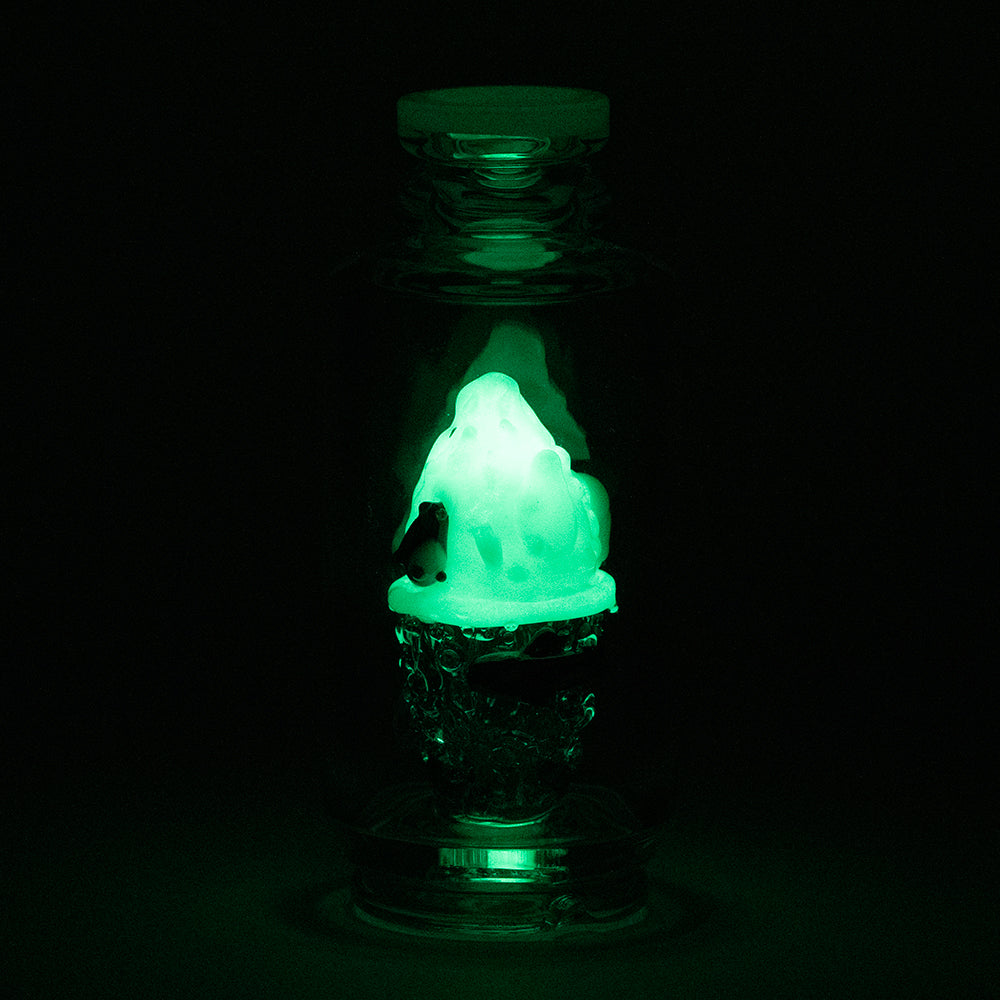 PuffCo Peak Glass Attachment glowing in the dark. The PuffCo glass features an iceberg and a penguin design. The puffco glass is desgined for use with puffco peak and puffco peak pro.